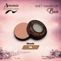 Open compact of Artemis aqua base makeup in shade 36 on a pink floral background.